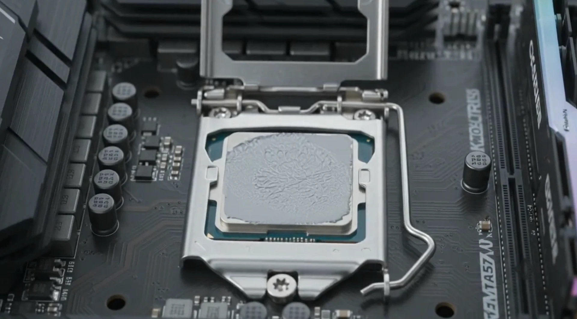 Desktop processor seated in an open LGA socket with fresh thermal compound applied